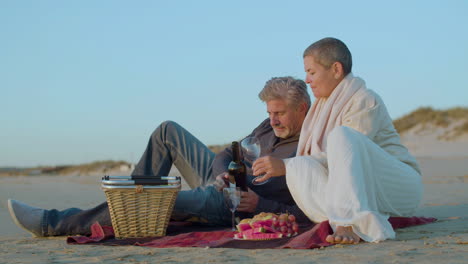 happy senior caucasian couple having a picnic on the beach