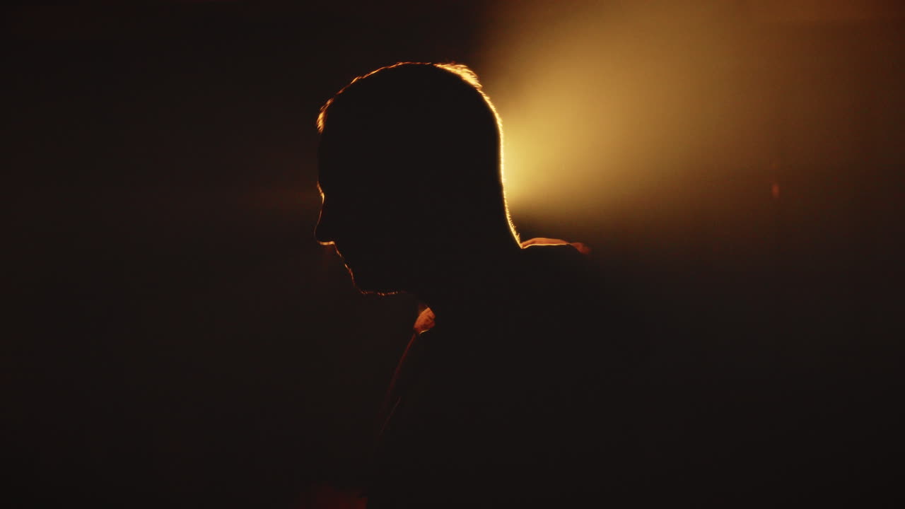 Anonymous Man Putting on Hoodie, Hiding Identity in studio sunset golden Light