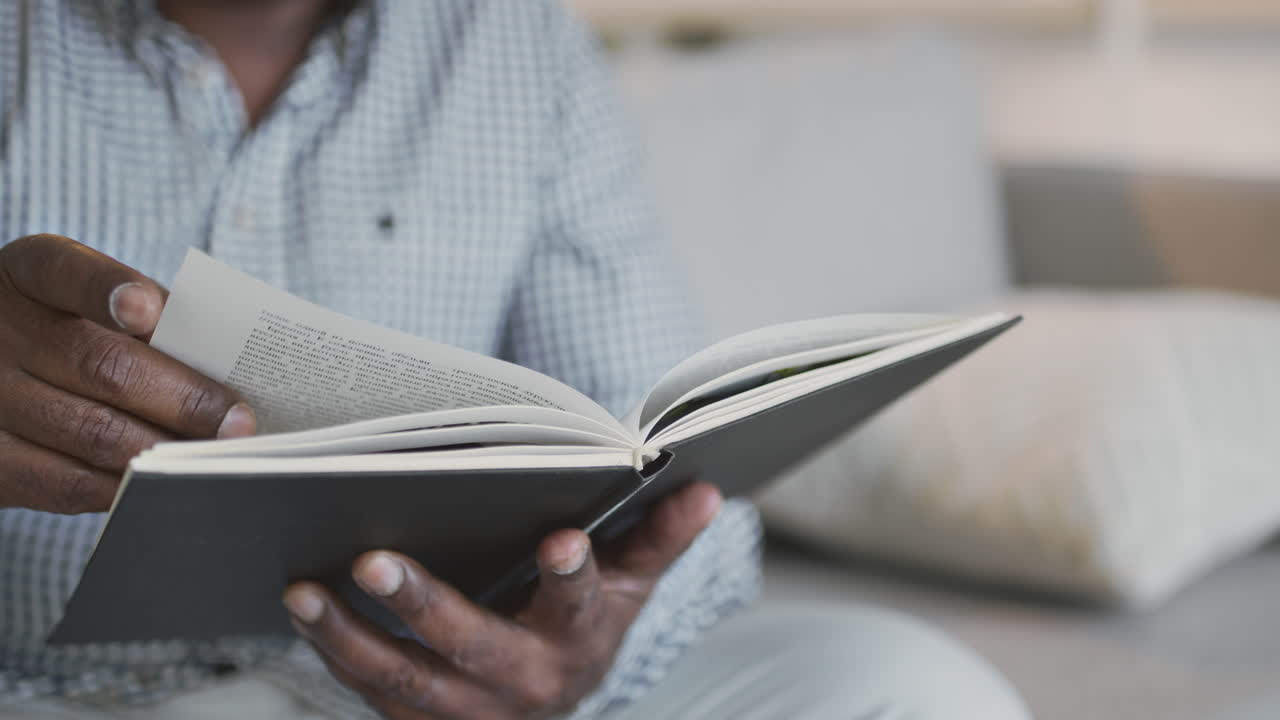 hombre leyendo un libro en un sofá