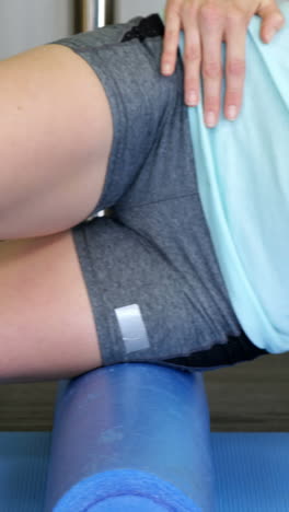 mujer realizando un ejercicio usando un rollo de espuma