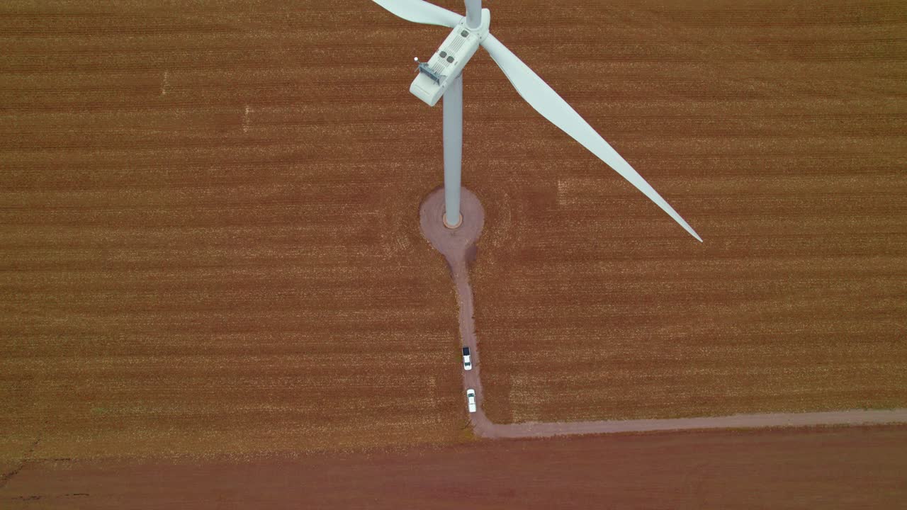Stunning top view of wind turbines stopped while drone checks for maintenance