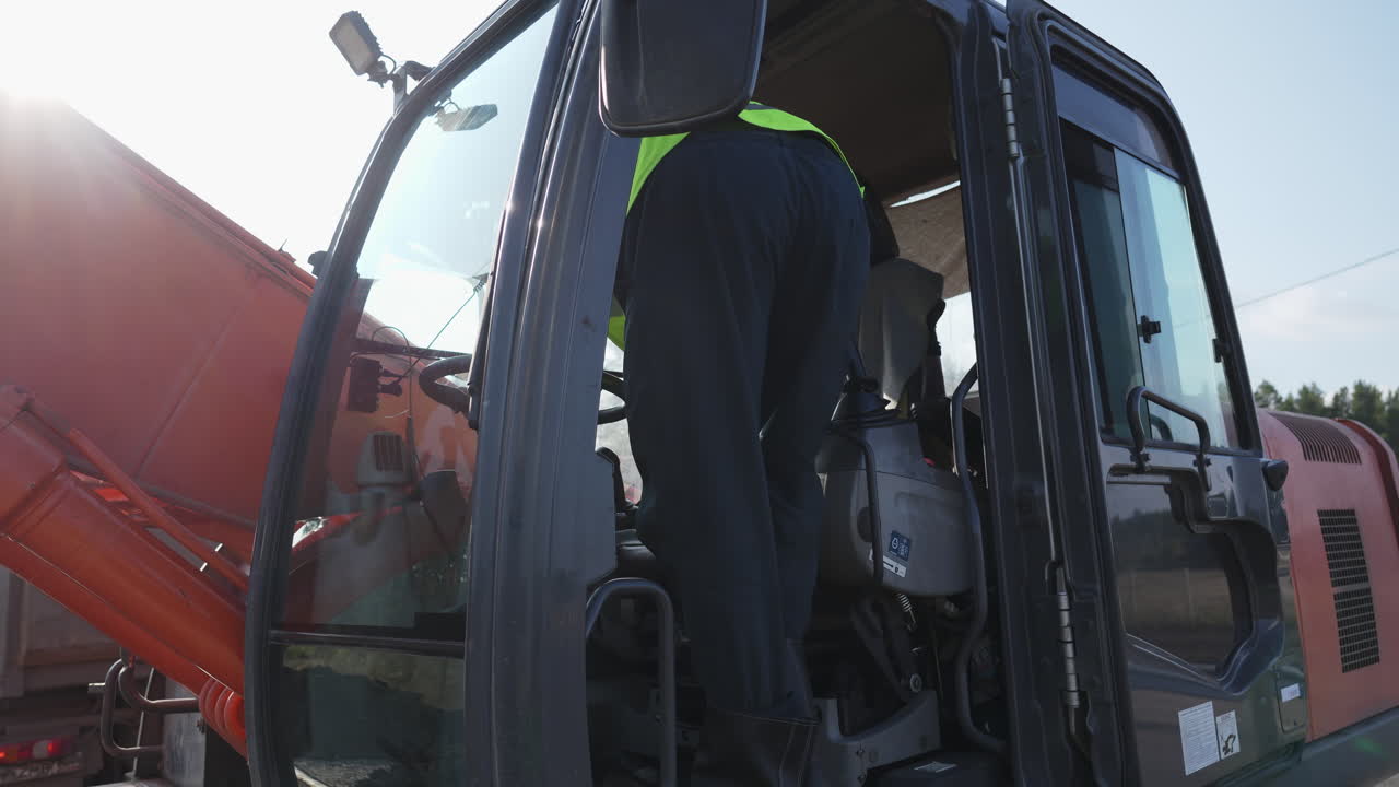Construction Worker Entering an Excavator Cab