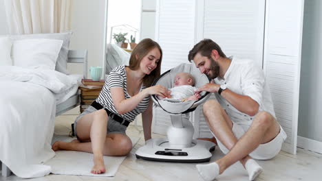 close up portrait of a happy parents watching their baby sleeping on a bed at home