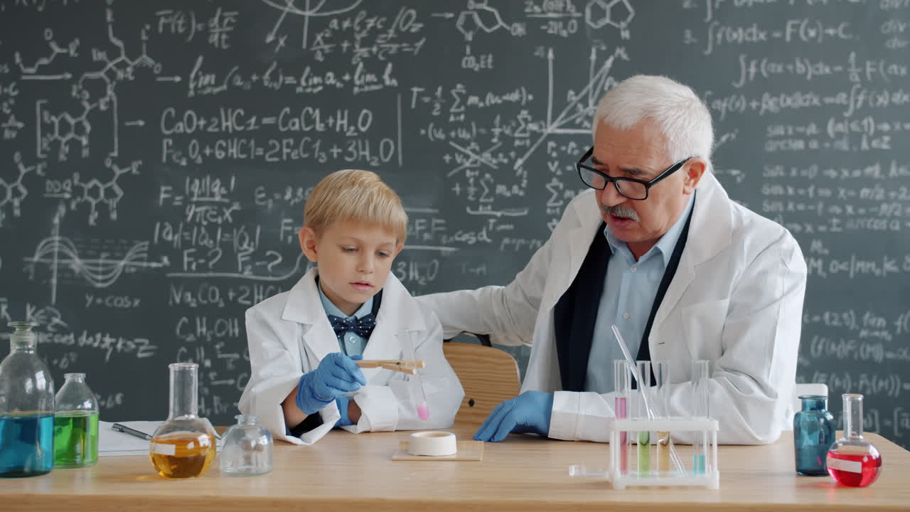 Young student learning chemistry with a teacher
