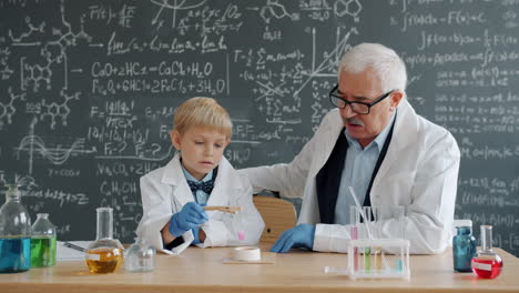 young student learning chemistry with a teacher