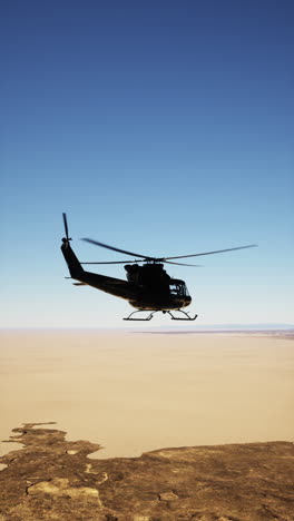 helicóptero negro volando sobre el desierto