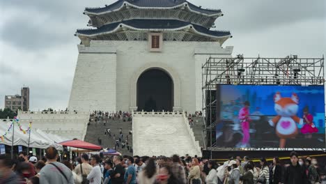 a lively time-lapse of busy festival crowds, a giant screen, and market stalls at liberty square with a view of chiang kai-shek memorial hall in taipei, taiwan, capturing the vibrant atmosphere.