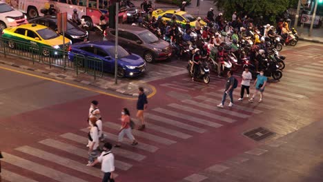 peatones y vehículos que cruzan una intersección de la ciudad