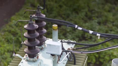 close-up of aged transformer equipment with cables and ceramic insulators