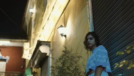 woman in contemplative mood looking over shoulder in an old town street at dusk with warm lighting