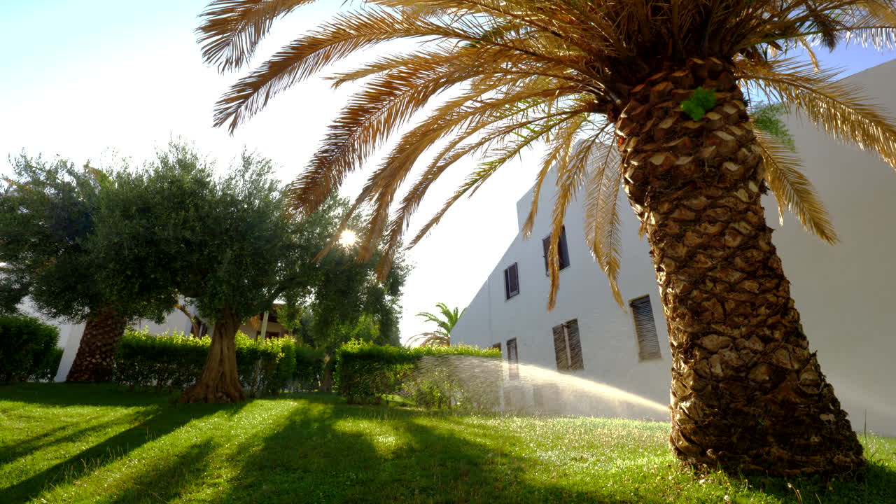 Innaffiare un giardino verde vicino alla casa estiva