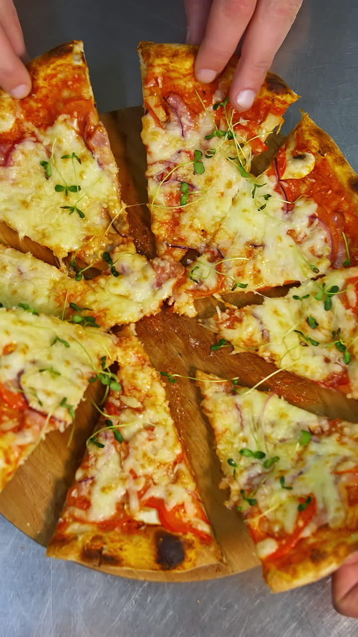 Hands Taking Slices Of Pizza. Hands taking pizza slices from wooden plate. Vertical video