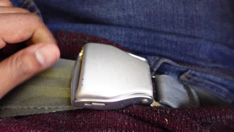 pasajero ajustando el cinturón de seguridad del avión