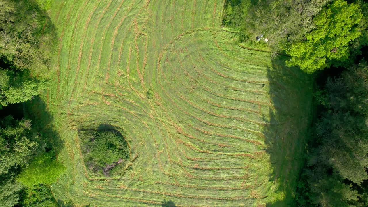 subiendo de arriba hacia abajo disparó a un gran campo de hierba después de cortar un tractor en francia durante un día soleado