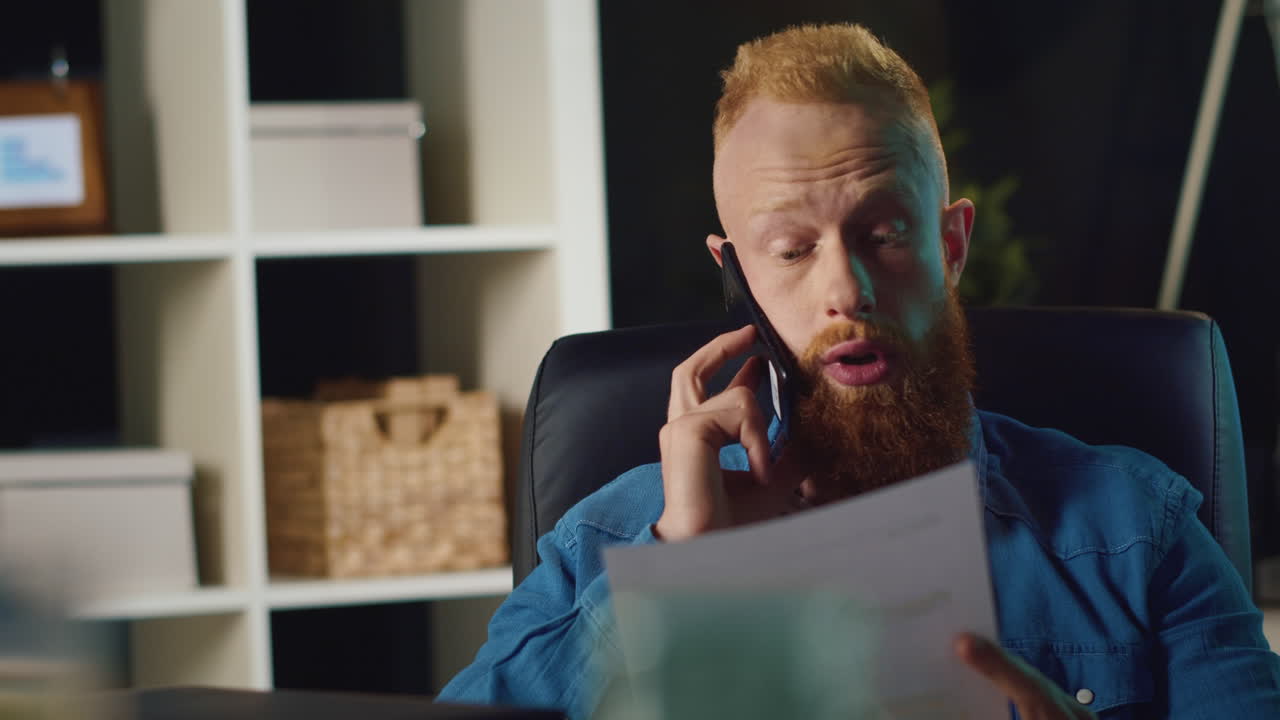 un hombre hipster hablando con su teléfono inteligente en el interior, un hombre de negocios comprobando documentos en el trabajo.