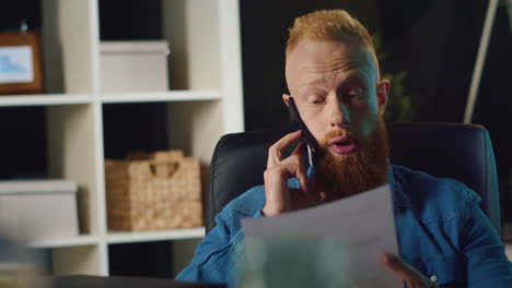 Hipster-man-talking-smartphone-indoors.-Businessman-checking-document-at-work.