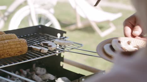 close up video of boy putting mushrooms on the grill