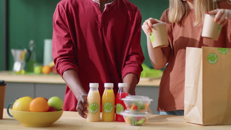 young diverse couple unloading healthy food and drinks from bag