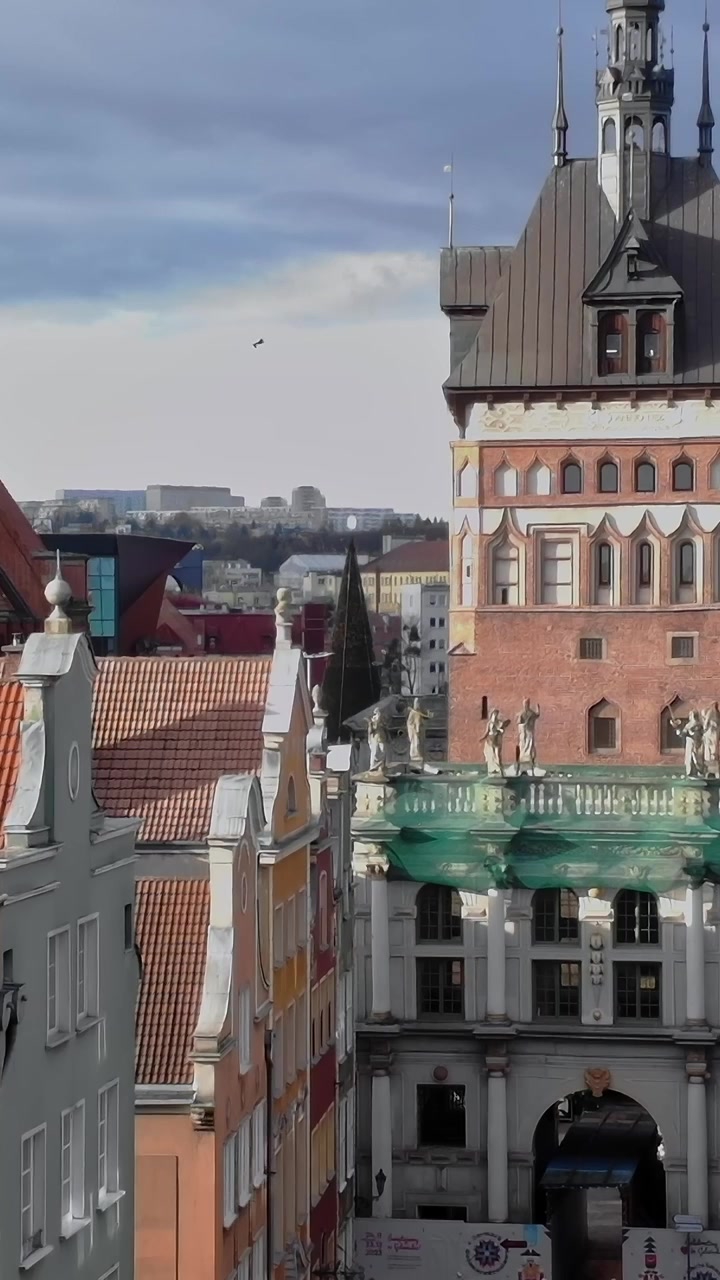 Vista di una strada di Danzica con edifici storici e persone che camminano sotto.
