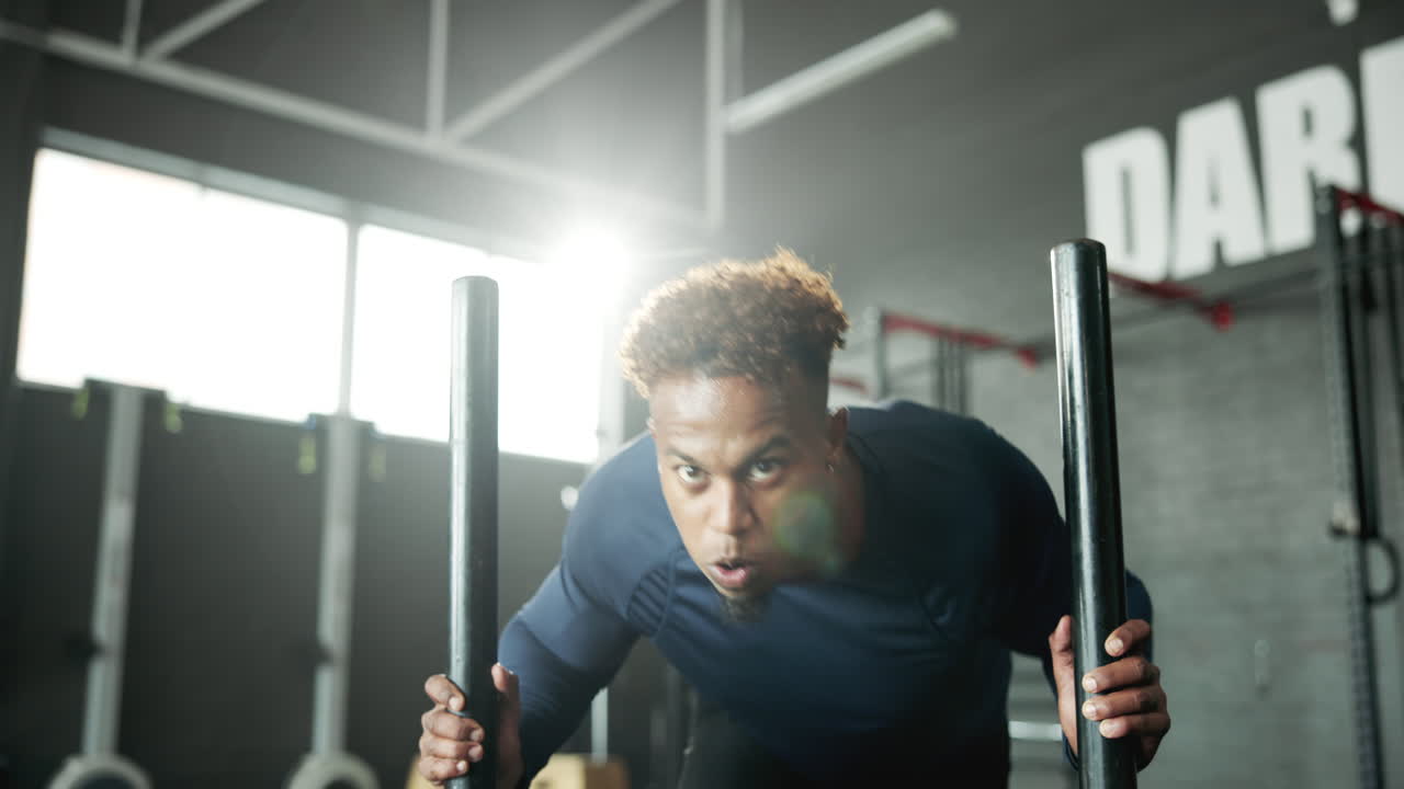 Man doing sled pushes in the gym