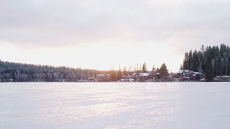 Frozen-Lake-With-Cabin-And-Mountain-Forest-In-The-Background-At-Sunrise-In-Trondheim,-Norway