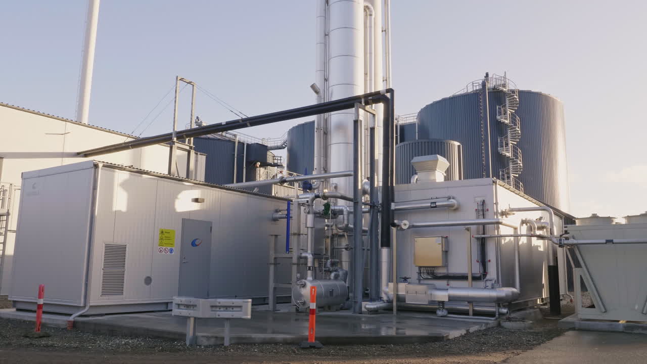 Detailed view of a modern biogas installation in rural Denmark, showing tanks, pipes, and clean energy infrastructure producing renewable gas from organic waste