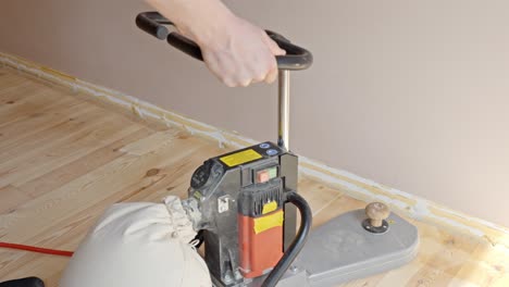 sanding wood floor edges using a professional tool to smooth the surface