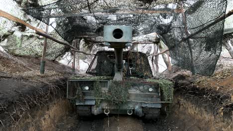 a menacing view down the barrel of a ukrainian pzh 2000 self-propelled howitzer. the german-made artillery is hidden in a fortified position, ready for a fire mission