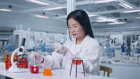 side view of asian woman scientist making experiment with test tube and microscope saying wow in laboratory. carrying out experiments, working in the lab analyzing her finding samples test tube