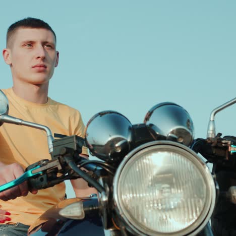 a guy and a girl are sitting on a motorcycle looking into the distance 2