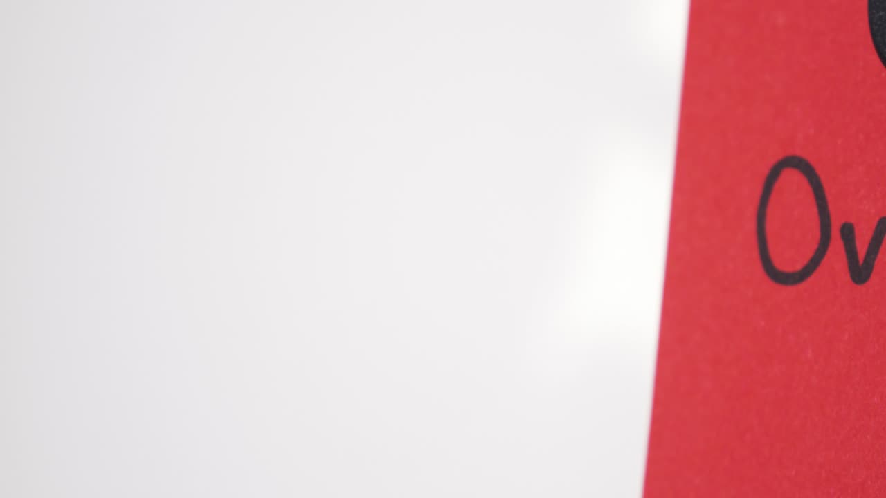 Pan reveal of Overdue text on red note held by magnet on whiteboard with selective focus