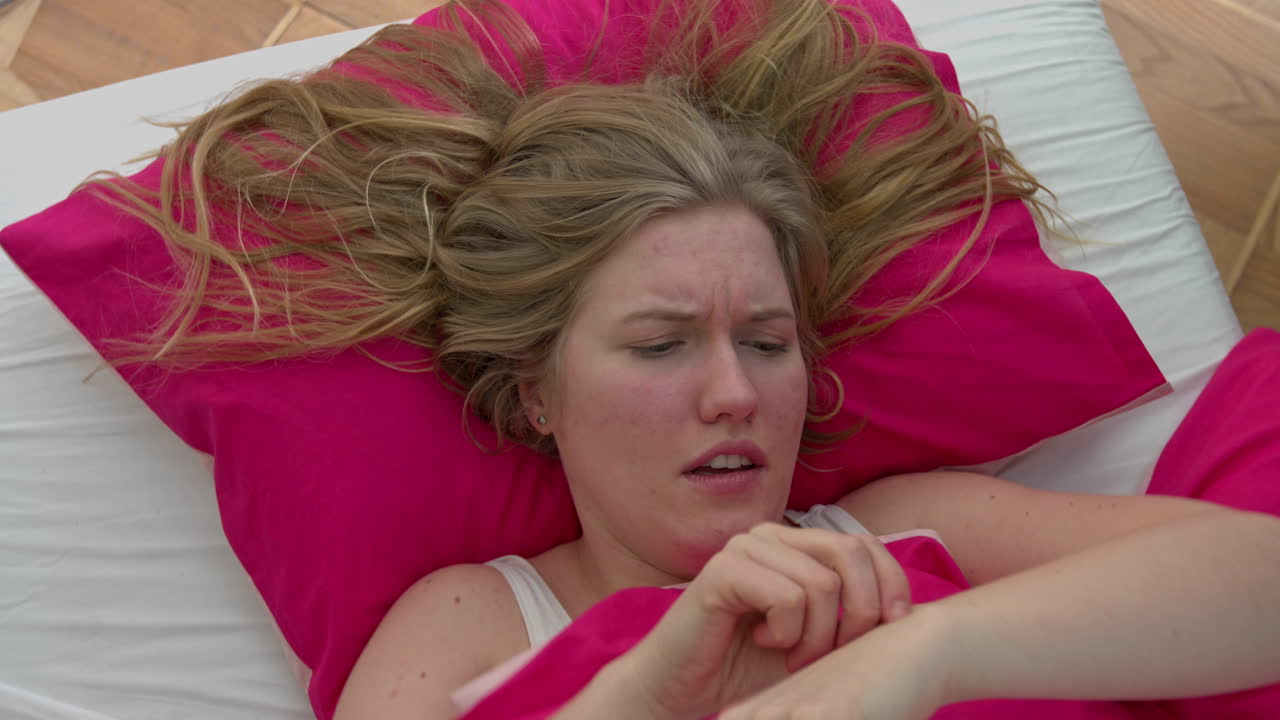 mujer molesta está acostada en la cama