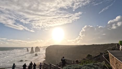 sunset over ocean cliffs with people observing