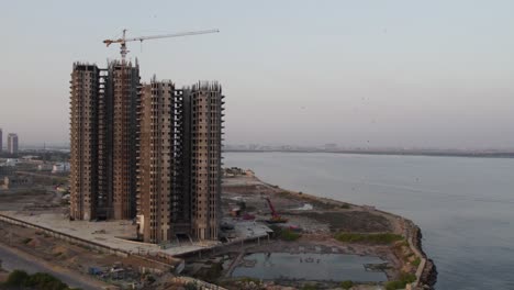 skyscrapers under construction by the sea at dawn