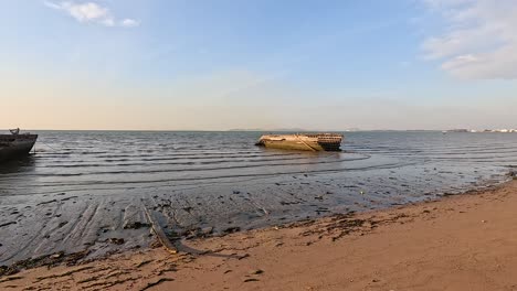 a boat rests on a sandy beach