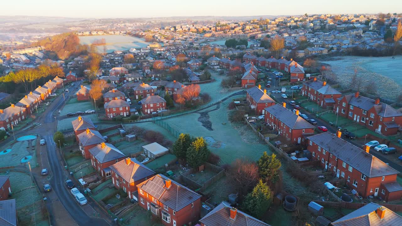 Drone's-eye winter view captures Dewsbury Moore Council estate's typical UK urban council-owned housing development with red-brick terraced homes and the industrial Yorkshire