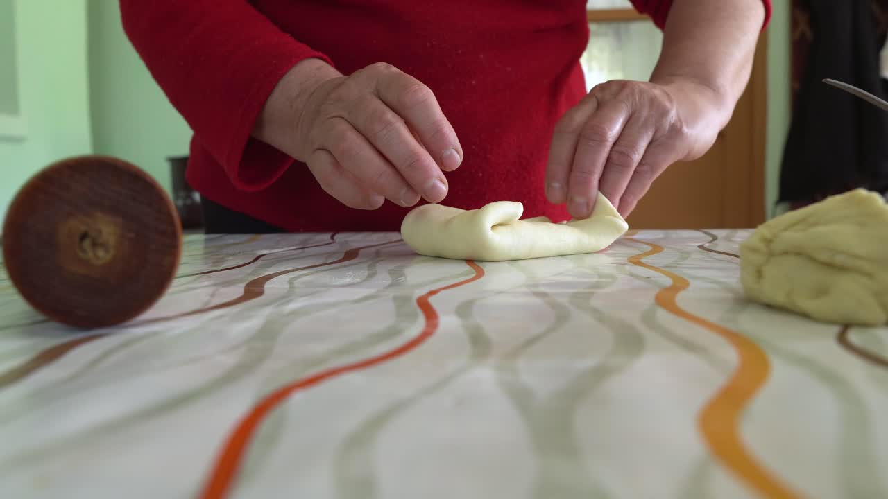 manos de una mujer envolviendo queso en masa para pasteles