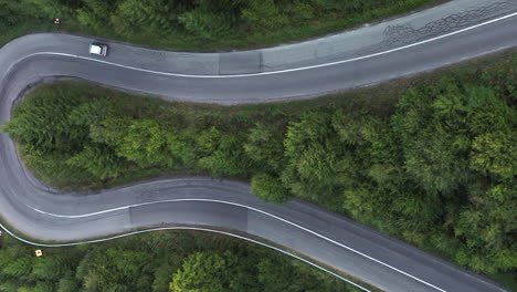 Vertical-bird's-eye-shot-of-a-curvy-mountain-road-in-Nyerges-Teto-Romania