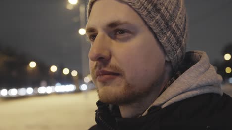 man lost in thoughts looks suspicious, wear winter clothes in city street