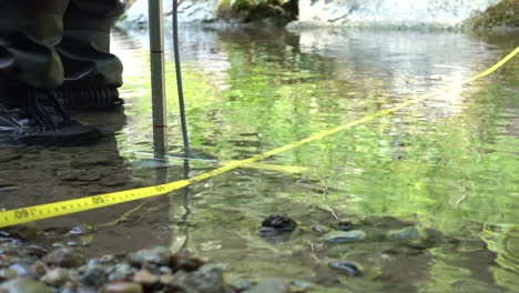 Yellow-magnetic-probe-used-to-measure-the-flow-of-a-Swiss-river-in-the-Alps,-environmental-sciences