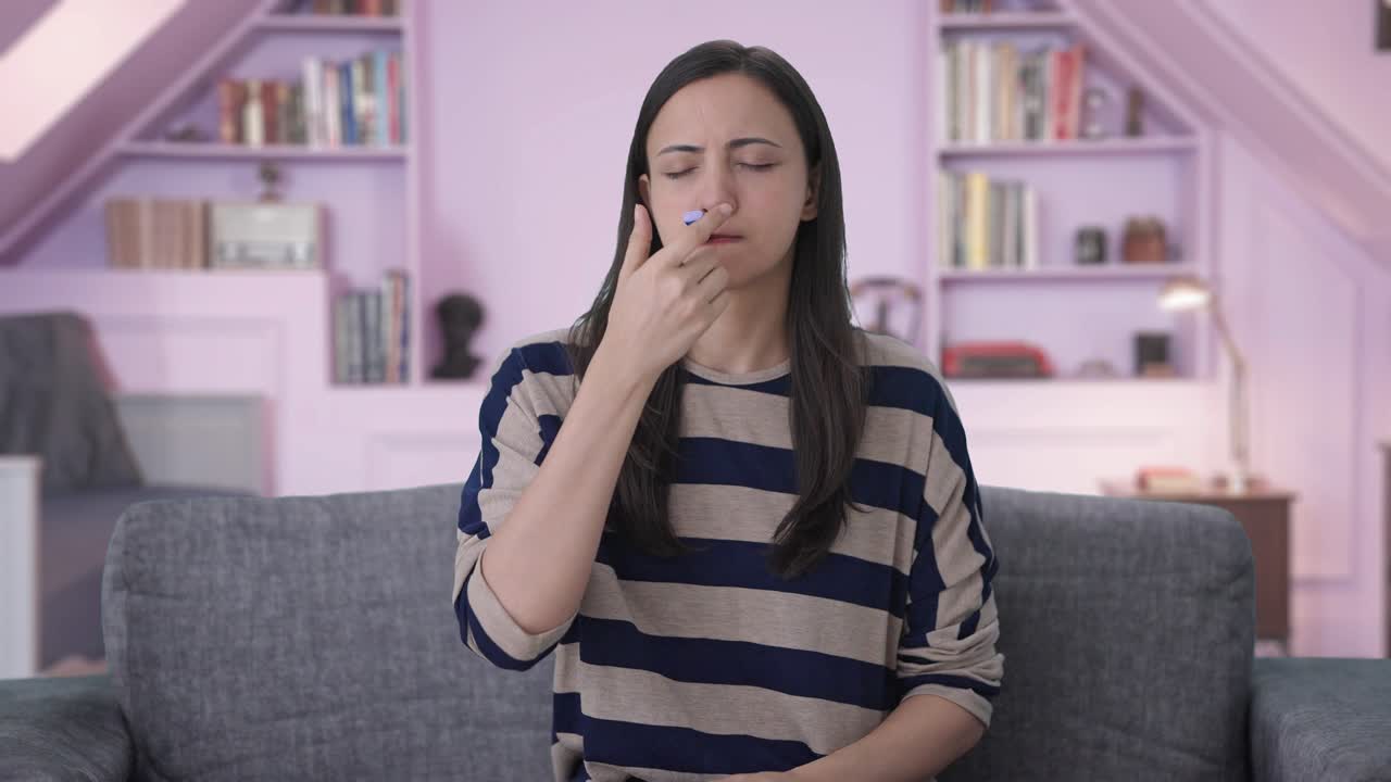 chica india enferma chequeando la fiebre