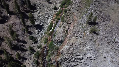 Aufnahme-Eines-Wasserfalls-Von-Oben,-Der-Die-Felsen-Eines-Berges-Hinabrieselt