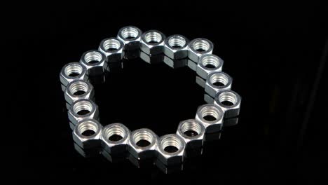metal nuts arranged in a circle on a black background