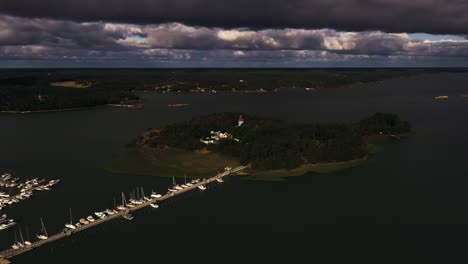 Aerial-view-circling-the-Moomin-island,-dramatic-clouds-above-Naantali,-Finland