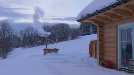 smoking furnace at dusk in winter next to cabin in poland, wide shot
