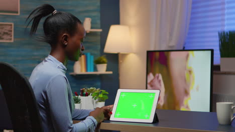 Focused-black-manager-woman-looking-at-tablet-with-green-screen