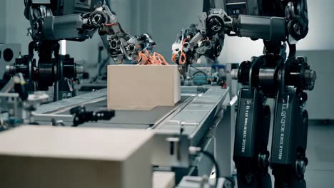 robots packaging boxes on a conveyor belt