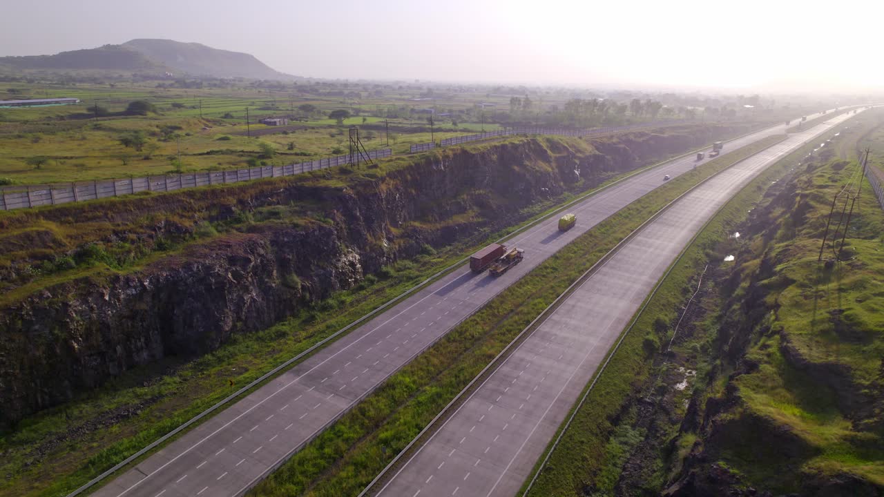 Mumbai Nagpur Expressway through western ghats green corridors under hazy sky, Maharashtra, Reveading drone shot