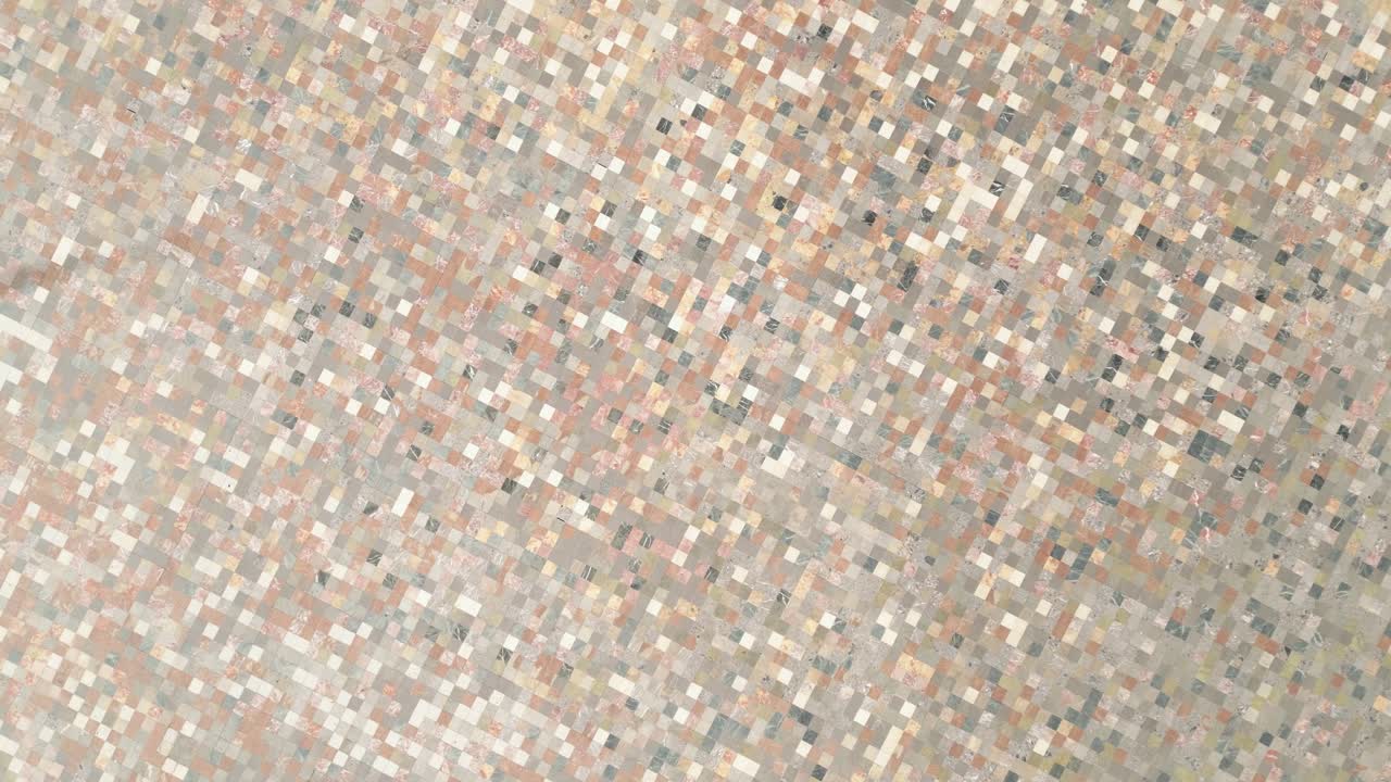 Vista verticale della piazza centrale di Tirana con persone che camminano nello spazio pubblico aperto.