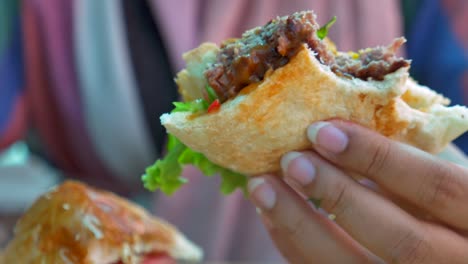 primer plano de una hamburguesa jugosa que se sostiene en la mano